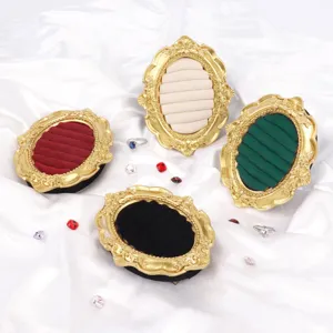 Vintage ornate gold oval jewelry display stands with velvet slots for rings and earrings