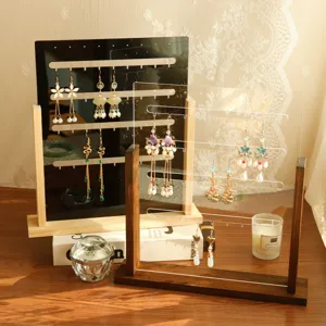 Elegant solid wood and acrylic earring display stand organizers with jewelry in warm sunlight