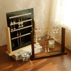 Solid wood and acrylic earring display stands shown in a warm lifestyle setting.