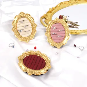 Macro view of vintage golden resin jewelry display frames with colorful velvet inserts.