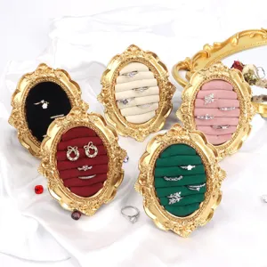 Vintage gold resin jewelry display stands with multi-color velvet inserts for rings.