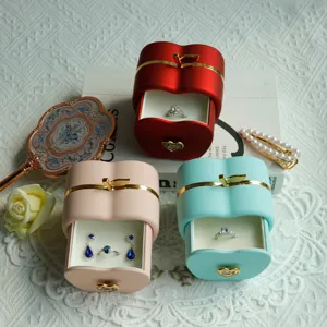 Detailed view of apple-shaped jewelry gift boxes with matte finish and gold accents.