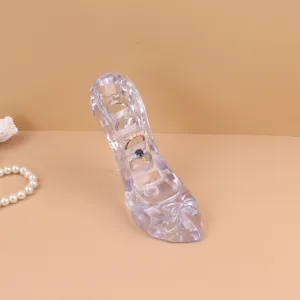 Detailed view of a creative crystal high heel jewelry stand holding four elegant rings