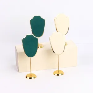 Vista detallada de elegantes soportes para collares de terciopelo y metal dorado en verde