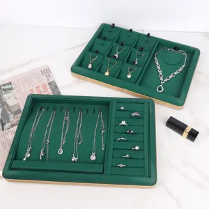 Detailed macro view of dark green PU leather jewelry display trays with gold trim accents
