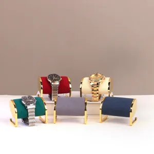 Detailweergave van fluwelen horlogestandaards met goudkleurige metalen frames in diverse kleuren