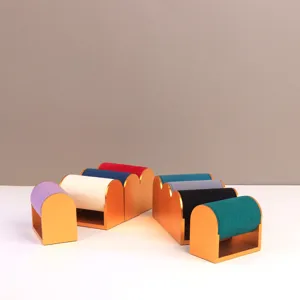 Dettaglio di supporti per orologi in velluto colorato con basi in metallo dorato