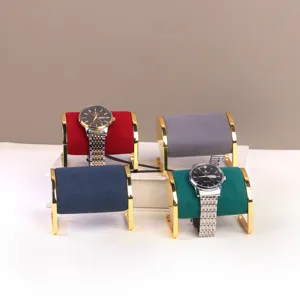 Set van vier fluwelen horlogestandaards met goudkleurige metalen frames.