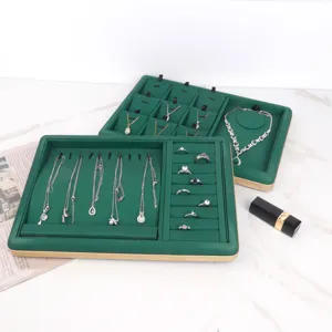 Detailed macro view of emerald green velvet jewelry trays with gold PU leather trim