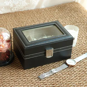 Detail showing the exterior stitching and silver clasp of the black leather watch box.
