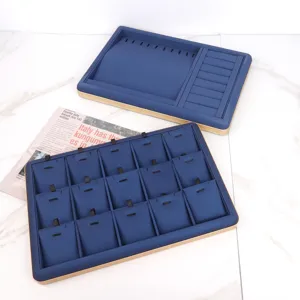 Detailed view of two blue PU leather jewelry display trays for rings and pendants with gold trim