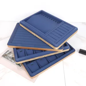Stack of premium blue PU leather jewelry display trays with gold trim and compartments