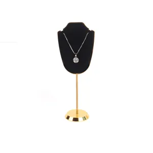 Vista detallada de un busto de collar de terciopelo negro en un soporte de metal dorado