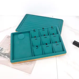 Close-up view of teal PU leather jewelry display trays with elegant gold metal frames