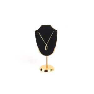 Elegante collar dorado con colgante rectangular sobre un soporte de terciopelo negro fino