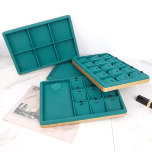 Detailed view of emerald green jewelry display trays with gold trim and velvet lining