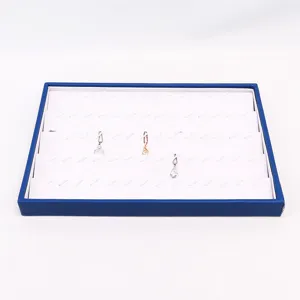 Rechthoekige blauw-witte gelaagde sieradendisplay voor oorbellen en kettingen.