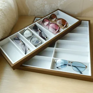 Detail eines Brillen-Display-Tabletts aus Holz mit weißen Fächern zur Aufbewahrung