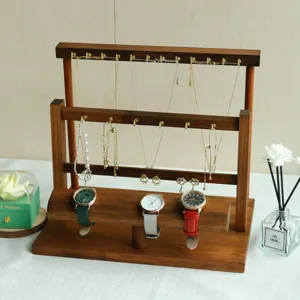 Detailed close-up of a walnut wood jewelry display stand with necklace hooks and watch bar
