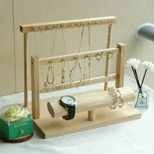 Detailed view of the tiered wooden jewelry stand with hooks for necklaces and watch bar