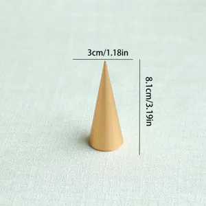 Dettaglio macro di un espositore per gioielli a cono dorato con misure precise