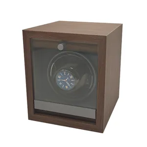 Close-up of vertical walnut wood automatic single watch winder with clear glass cover.