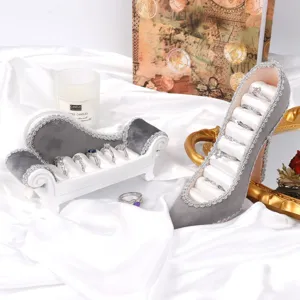 Détail macro d'élégants porte-bijoux canapé et chaussure en velours gris avec bagues