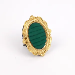 Vintage gold ornate resin jewelry display stand with green velvet slots for rings