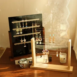 Wooden earring display stands in black and clear acrylic with warm sunlight detail.