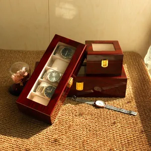 Vista detallada de cajas de relojes de madera lacada en rojo con luz ambiental cálida
