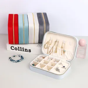 Detailed view of portable velvet jewelry box showing internal compartments and color options
