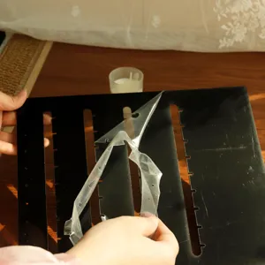 Detail of removing protective film from black acrylic earring display board