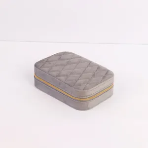 Side view of gray velvet jewelry organizer box with gold zipper and quilted pattern