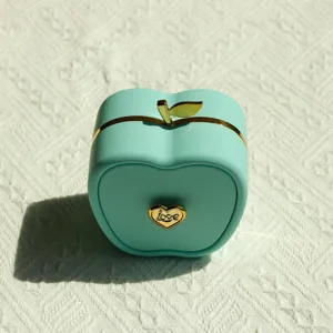 Detailed view of mint green apple-shaped jewelry box showing golden Love heart clasp detail