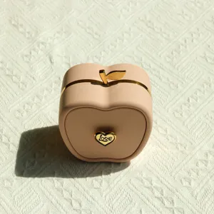 Detailed view of peach apple-shaped jewelry gift box with gold heart Love emblem
