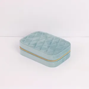 Detailed macro view of a light blue quilted velvet jewelry box with gold zipper