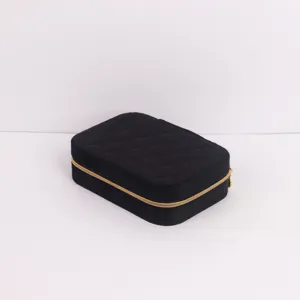 Detailed close-up view of portable black quilted jewelry box with gold zipper for travel