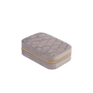 Elegant grey quilted velvet travel jewelry box with a secure golden zipper closure