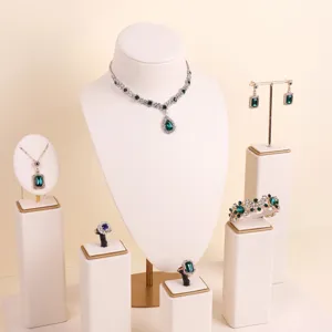 Elegant cream microfiber jewelry display stands with luxury green gemstone jewelry set.