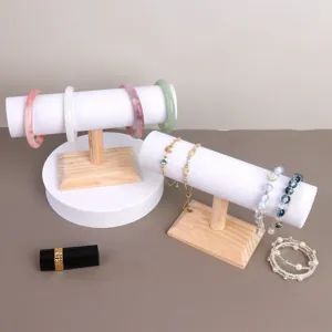 Detailweergave van twee houten T-vormige sieradendisplays met verschillende armbanden