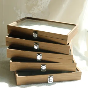 Detail of stacked walnut wood grain jewelry boxes with glass lids and metal latches