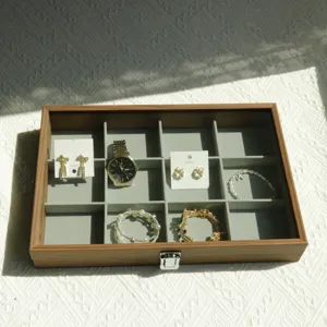 Detailed view of a walnut wood jewelry box with 12 compartments and a glass lid
