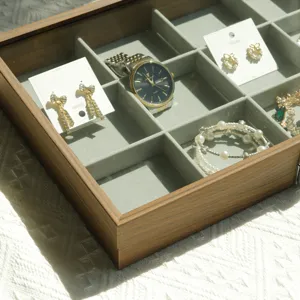 Macro view of walnut wood grain jewelry box showing multiple storage grids and soft lining