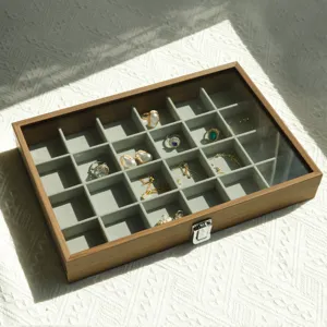 Detailed top view of walnut wood jewelry box with 24 compartments and glass lid.
