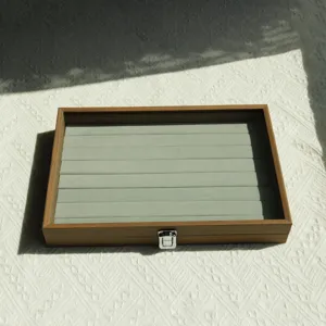 Walnut wood grain jewelry storage box with grey velvet ring slots and transparent lid