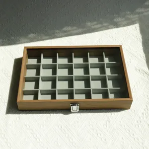 Detailed view of the 24-compartment walnut wood grain jewelry box with velvet lining.