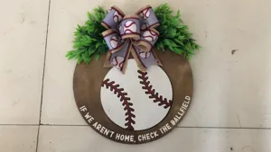 Wooden baseball door sign with green leaves and ribbon bow, perfect for front door home decor.