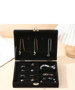 Detailed interior view of a black velvet jewelry box with rings and necklaces