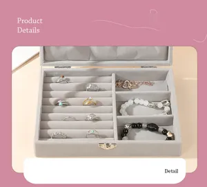 Detailed view of open gray velvet jewelry organizer box filled with rings and bracelets