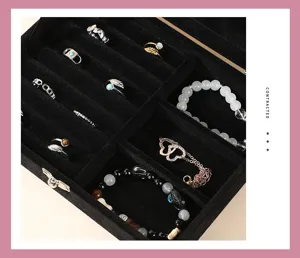 Detail view of black velvet jewelry box interior showing rings and bracelets organized